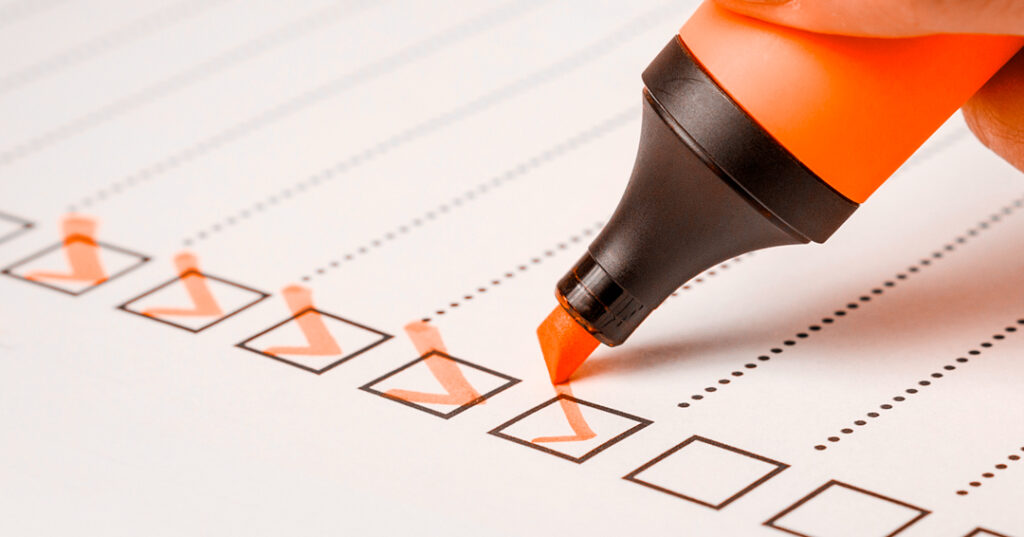 Lista de tareas en la que una persona está marcando como completadas las diferentes casillas que aparecen con un rotulador naranja